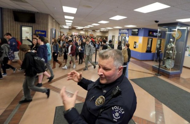 Bremerton school resource officer Matt Strombach, of the Bremerton Police Department, talks about his role at the school as students head for their classes after lunch period Tuesday at Bremerton High School. (Meegan Reid / Kitsap Sun)