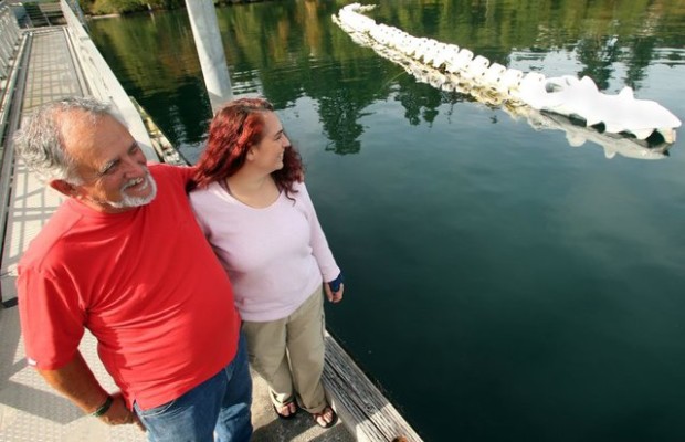 Terry Asla and daughter Colleen Asla-Dobbin admire their sculpture from the dock at the Brownsville Marina. (Meegan Reid / Kitsap Sun)